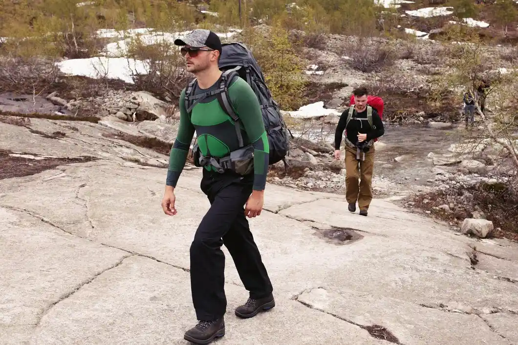 Two-hikers-walking-up-mountain-with-backpacks