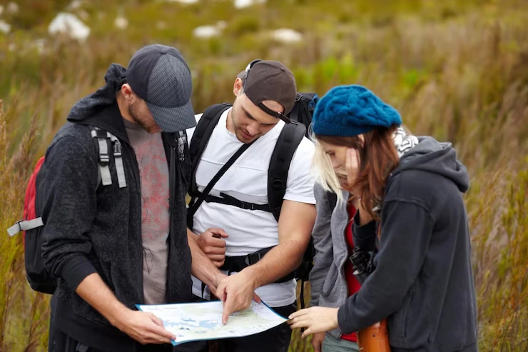 four-hikers-looking-at-map-together-outdoors
