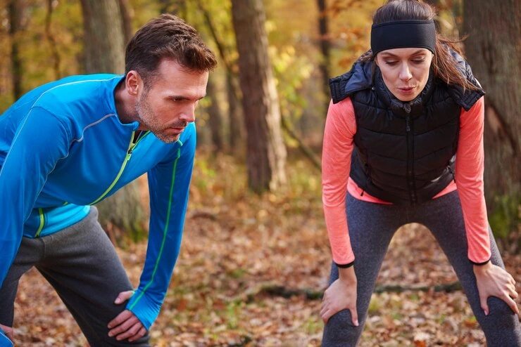 two-friends-catch-their-breath-after-exercise-in-forest